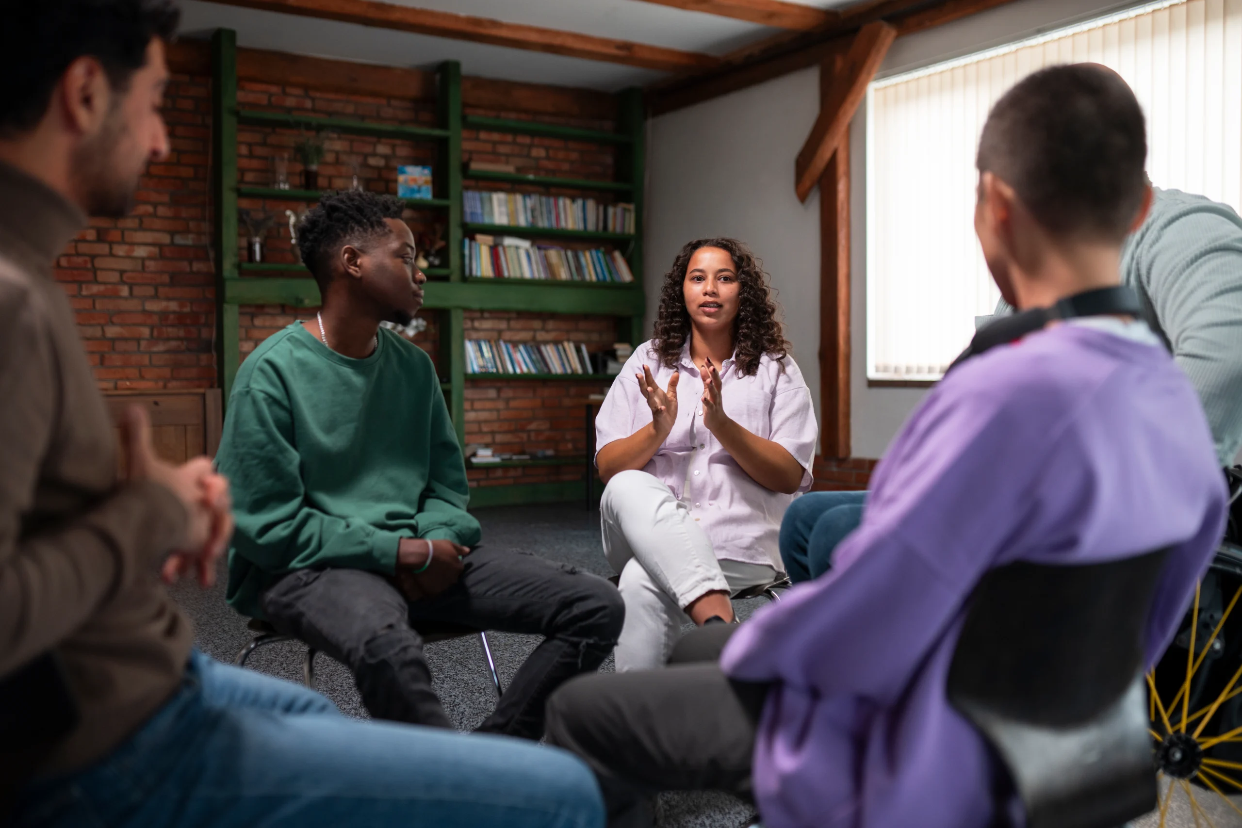 Equipe reunida em círculo participando de uma sessão de comunicação e segurança psicológica.
